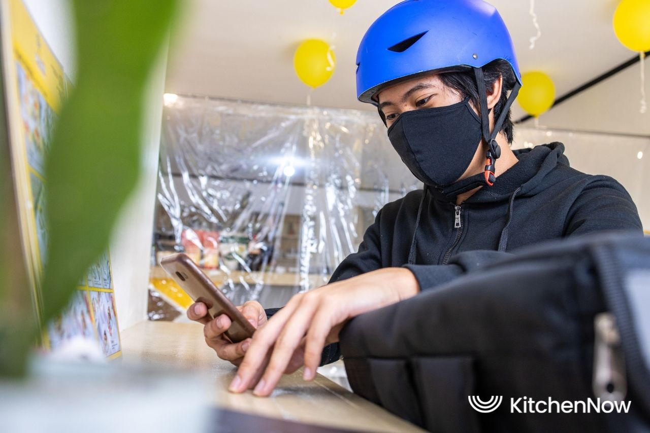 asian-food-delivery-rider-checking-phone-order