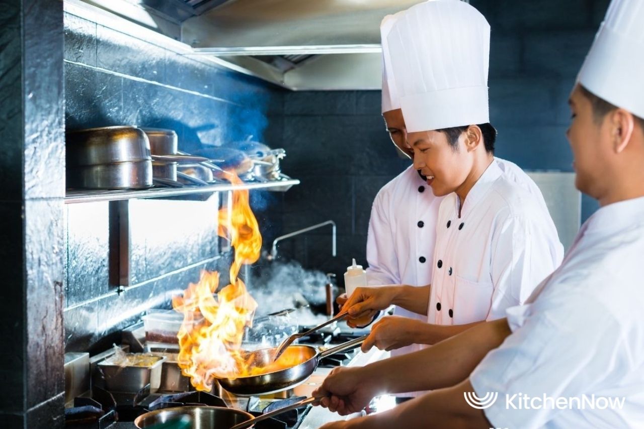 group-of-chefs-cooking-in-kitchen-with-wok